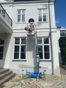 installing PhoebeNewYork on upper level of outside of building with cherry picker lift